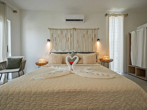 boho bedroom with macramé headboard, swan towel art, and mini-split ac