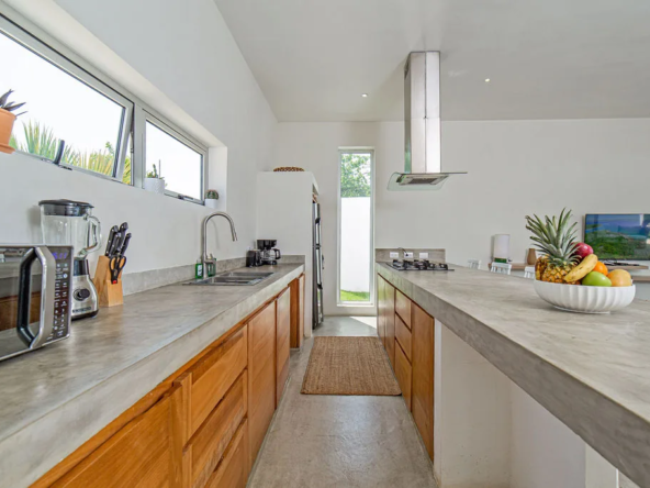 modern kitchen with concrete countertops, wood cabinets, and fruit bowl