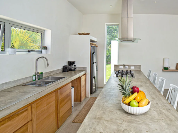 modern kitchen with concrete counters, fruit bowl, and dining area
