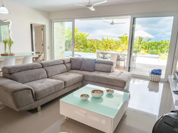 modern living room with gray sectional sofa and pool view