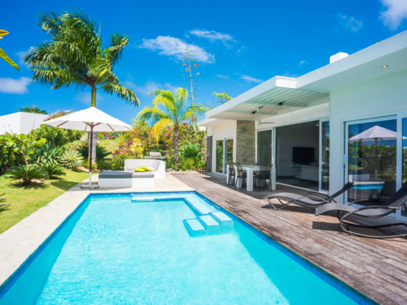 luxury villa pool deck with lounge chairs and tropical garden